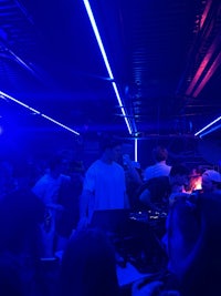 a group of people in a room with blue lights